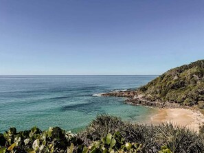 A coastal landscape with clear water, a sandy beach, and vegetation. - 4 Allura Circuit Coolum Beach (Coolum Beach)