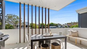 Ein Balkon mit Tisch, Stühlen und Grill.