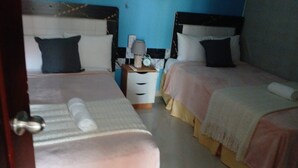 A room with two beds, a nightstand with a lamp, and a wall clock. - Vacation in punta cana (Punta Cana)