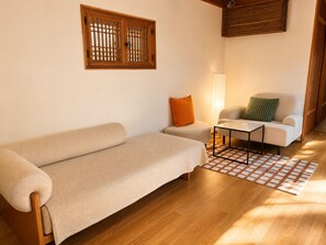 Ein gemütliches Wohnzimmer mit einer Couch, einem kleinen Tisch und einer Lampe.
