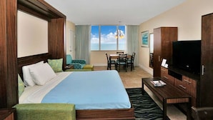 A hotel room with a bed, a TV, a desk, and a view of the sky. - Cozy Studio condo with AC in amazing Hollywood (Hollywood)
