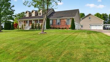 A two-story house with a front porch, a garage, and a well-maintained lawn.