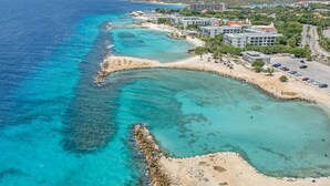 A coastal resort with beachfront villas, clear turquoise waters, and a mountainous backdrop. - Casa Piscadera · Ocean View · Pool · Beaches (Piscadera)