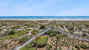 A beach with a wooden boardwalk, sandy dunes, and sparse vegetation. - Luxury Oceanfront 2 bed 2 bath Condo - Stunning (Fernandina Beach)