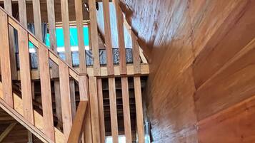 Eine Holztreppe mit Geländer, die zu einer oberen Ebene führt.