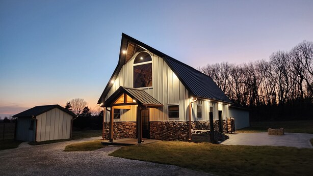 A house with a stone foundation, a large arched window, and a sloped roof. - The Barn at Reed | Hot Tub + Horse Friendly (Reeds)
