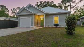 A single-story house with a garage, a front door, and a small front yard.