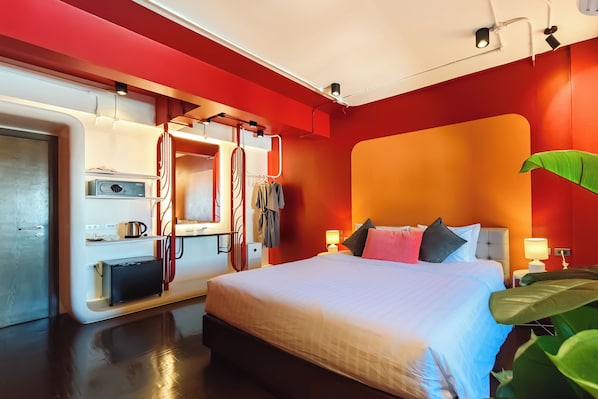 Une chambre d’hôtel moderne avec un grand lit, des tables de chevet, une armoire intégrée et un miroir.