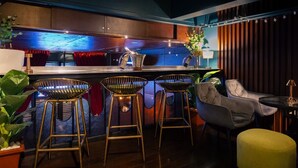 A bar area with stools, a bar counter, and a seating area with a table and chairs. - DAY & NIGHT by THE MOMENT (Chiang Mai)