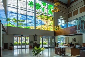 A spacious lobby with large windows, a staircase, and seating areas. - Cozy 1-bedroom condo with AC in fabulous Oranjestad (Oranjestad)