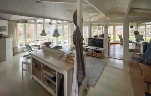 A spacious kitchen with a dining area, large windows, and a view of the outdoors.