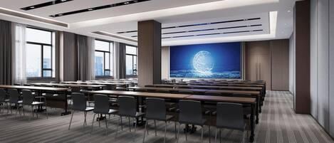 A modern conference room with rows of tables and chairs, large windows, and a projection screen displaying a globe.
