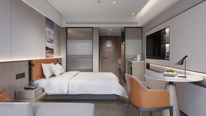 A modern hotel room with a bed, a desk, a chair, a small table, and a television. - Mehood Lestie Hotel Lanzhou Wanda Plaza (Lanzhou)