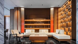 A modern lobby with a sectional sofa, a coffee table, and a seating area with chairs. - Mehood Lestie Hotel Lanzhou Wanda Plaza (Lanzhou)