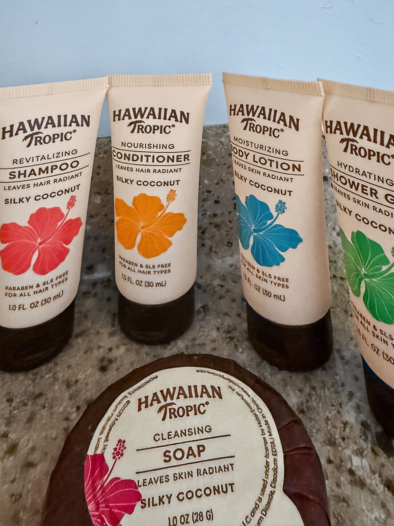 Four bottles of Hawaiian Tropic hair care products and one bar of cleansing soap.