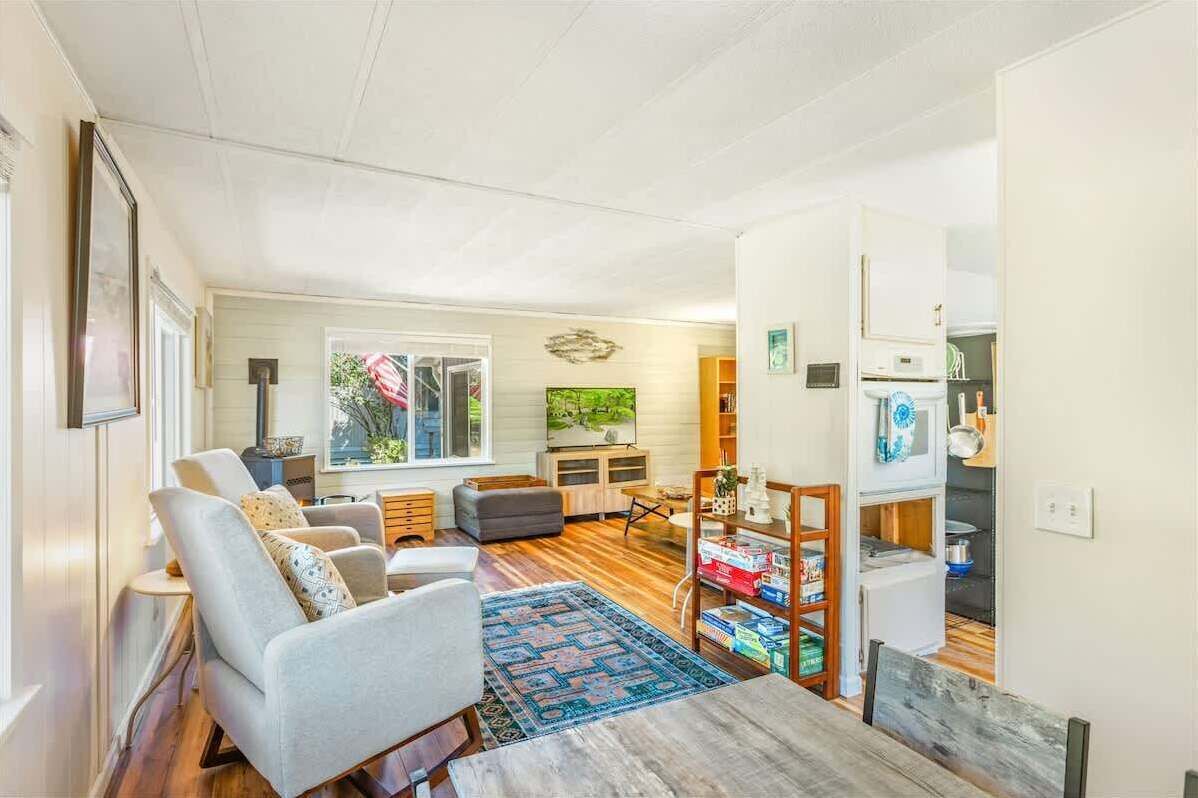 Una sala de estar con un sofá, una mesa de centro, una alfombra y un televisor.