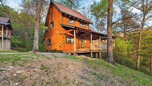 A wooden cabin with a balcony, surrounded by trees. - Isaiah's Cabin by Avantstay Private Hot Tub + Fire Pit + Mountain Views Near Smokies + Townsend (Townsend)