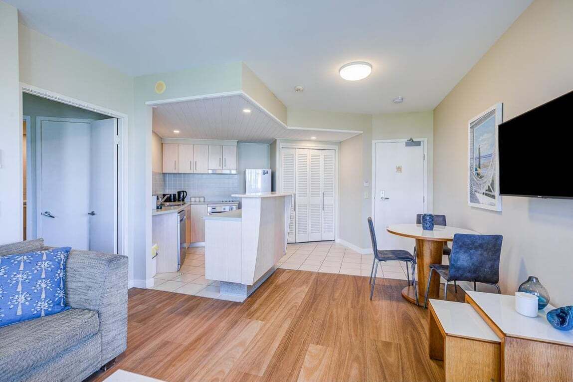 A modern apartment with a living room, kitchen, and dining area.
