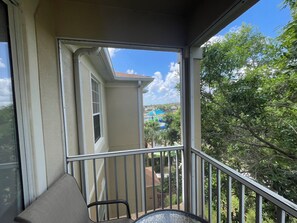 A balcony with a view of a house and trees. - Spectacular Views! 2 Bedroom Apartment in Windsor Hills Resort (Kissimmee)
