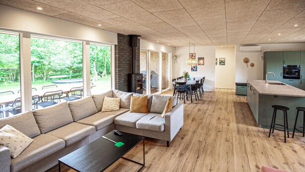 A modern living room with a sofa, a coffee table, and a dining area with chairs. - Beautiful home in Skjern with sauna (Skjern)
