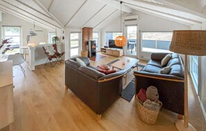 A spacious living area with a fireplace, sofas, a TV, and large windows. - Gorgeous home in Hvide Sande with sauna (Hvide Sande)