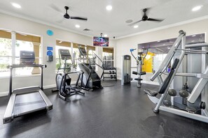 A gym with treadmills, elliptical machines, and weightlifting equipment. - Beds for 8 Windsor Hills Condo close to the clubhouse (Kissimmee)