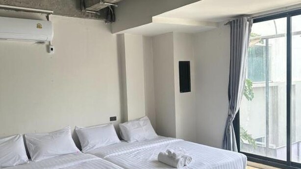 Ein Hotelzimmer mit Bett, Fenster und Deckenlüfter.