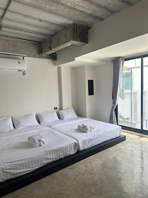 A hotel room with a bed, a window, and a ceiling vent. - Collection O Lamoon Patong (Patong)