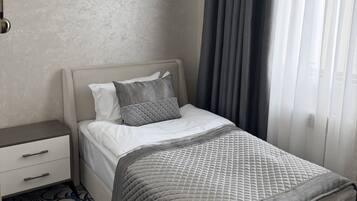 A hotel room with a bed, a nightstand, a lamp, and a patterned carpet.