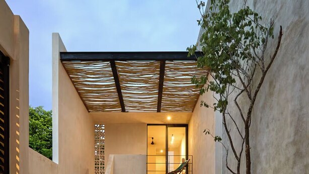 Un'area piscina moderna con piscina cristallina, un'amaca e una scalinata che conduce a un livello superiore.