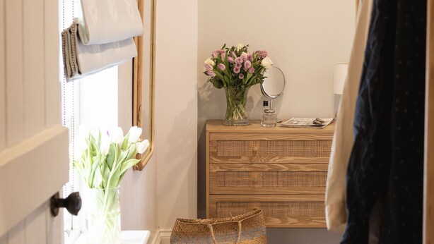 A narrow hallway with a wooden floor, a woven basket, a wooden bench, and a mirror on the wall. - The Smithy's Cottage -  a cottage that sleeps 4 guests  in 2 bedrooms (Freston)