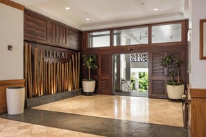 A hotel lobby with a wooden reception desk, a bamboo wall, and a glass door entrance. - 11Fl Ilikai studio w/ great ocean views & 2 pools (Honolulu)