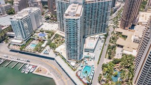 Ein Hochhotel mit zahlreichen Stockwerken, einem Pool auf dem Dach und einer Marina mit Booten.