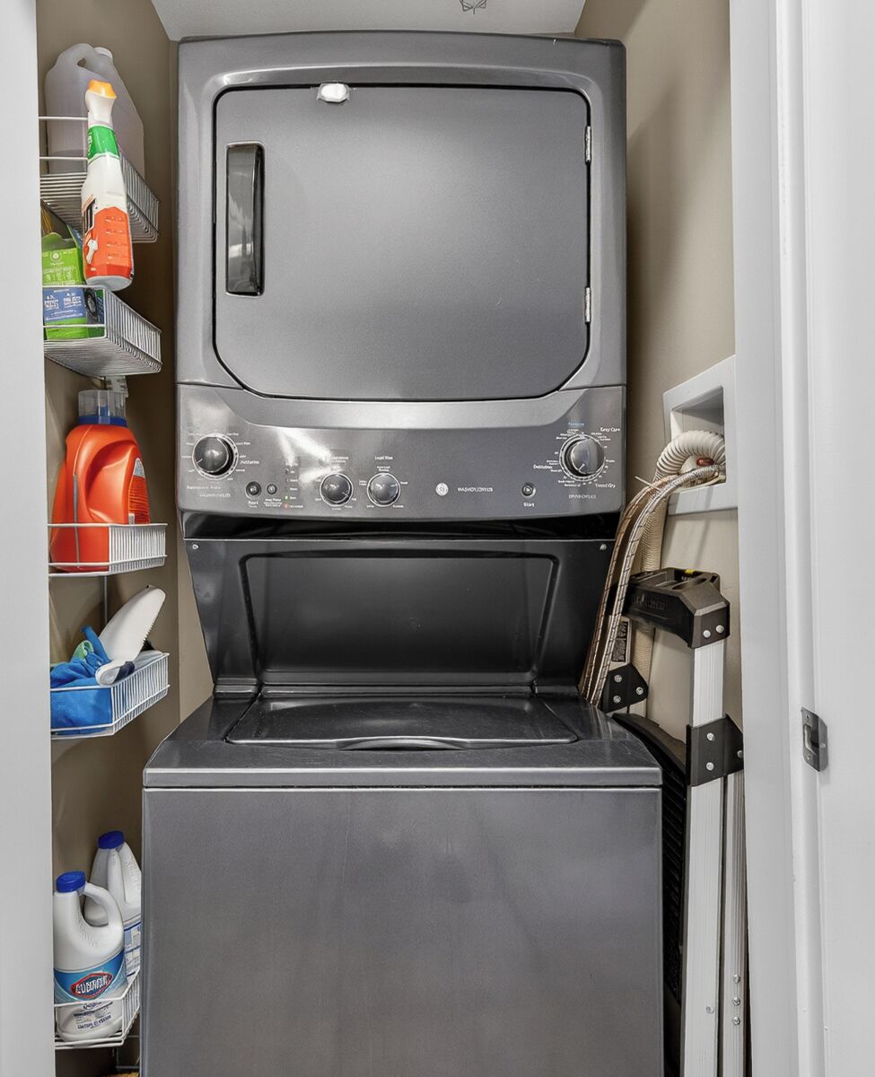 A compact laundry room with a top-loading washing machine and a front-loading dryer.