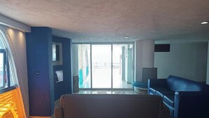 Ein modernes Wohnzimmer mit einer Couch, einem Fernseher und einem großen Fenster.