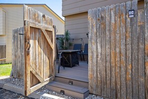A wooden gate leading to a patio with a table and chairs. - Afton Oaks: Cozy Westside Retreat • 2BR Townhome Near Garden of the Gods (Colorado Springs)