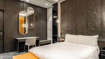 Une chambre d’hôtel moderne avec un grand lit, un bureau et un miroir.