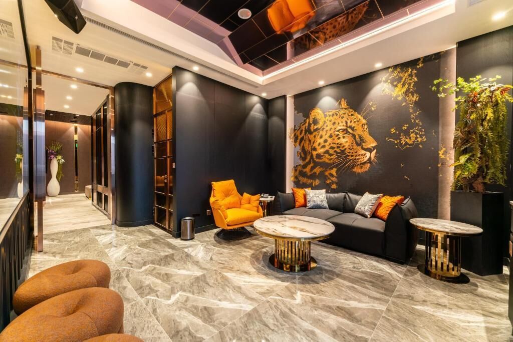 A modern lobby with a large leopard mural, a sofa, a coffee table, and a plant.