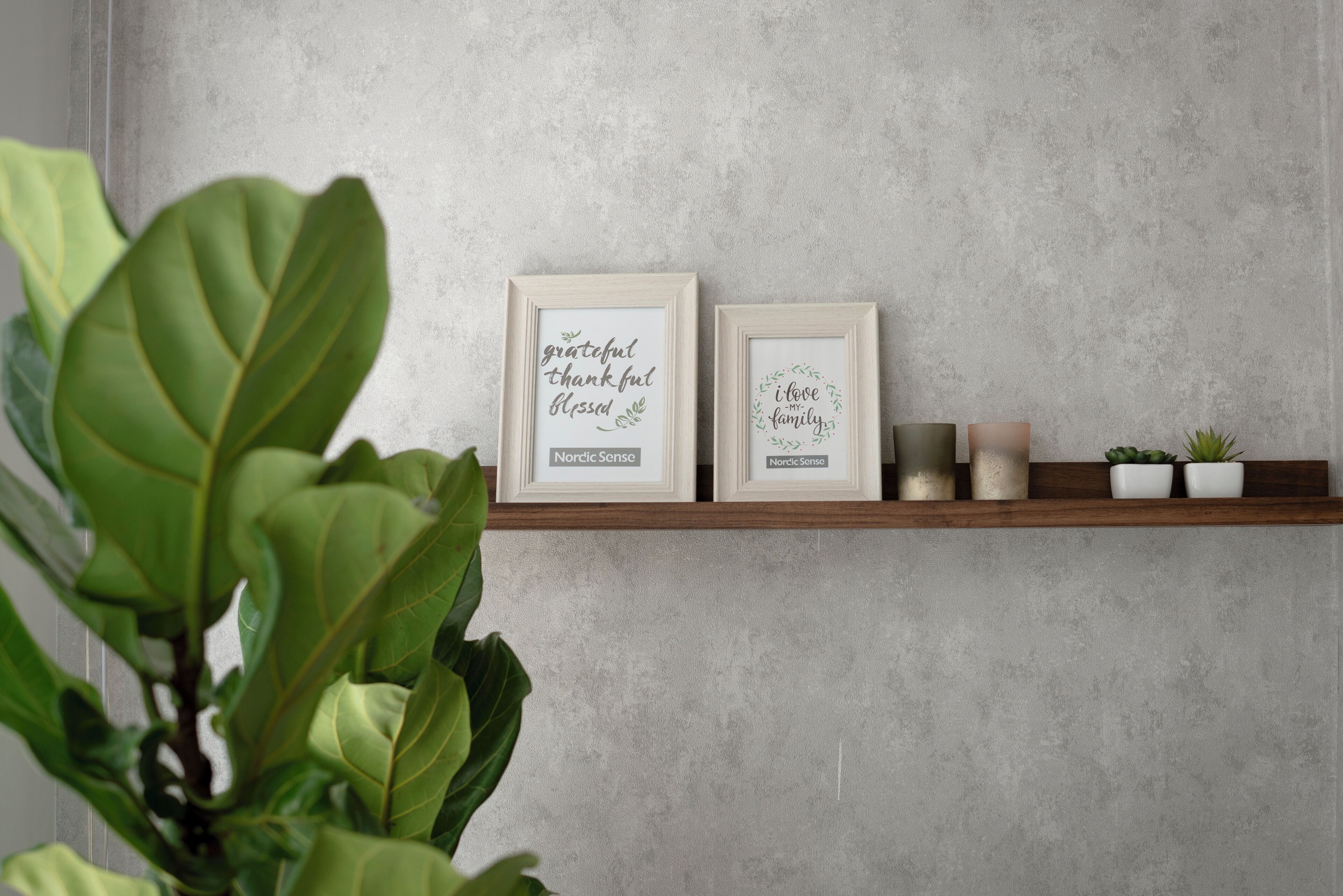 Two framed signs with text on a shelf against a textured wall.