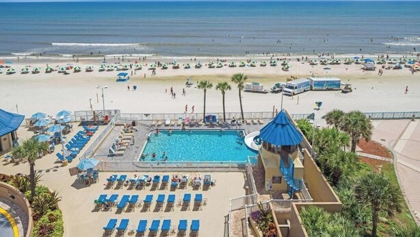 Ein Resort mit Pool, Strand und Palmen.