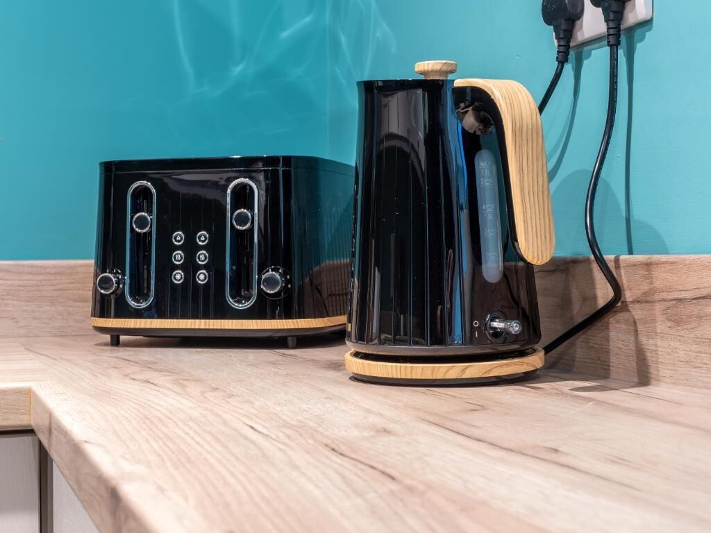 Two black appliances with wooden accents on a countertop.