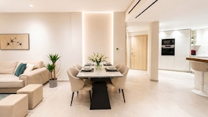 Una sala moderna con una mesa de comedor, sofá y zona de cocina.