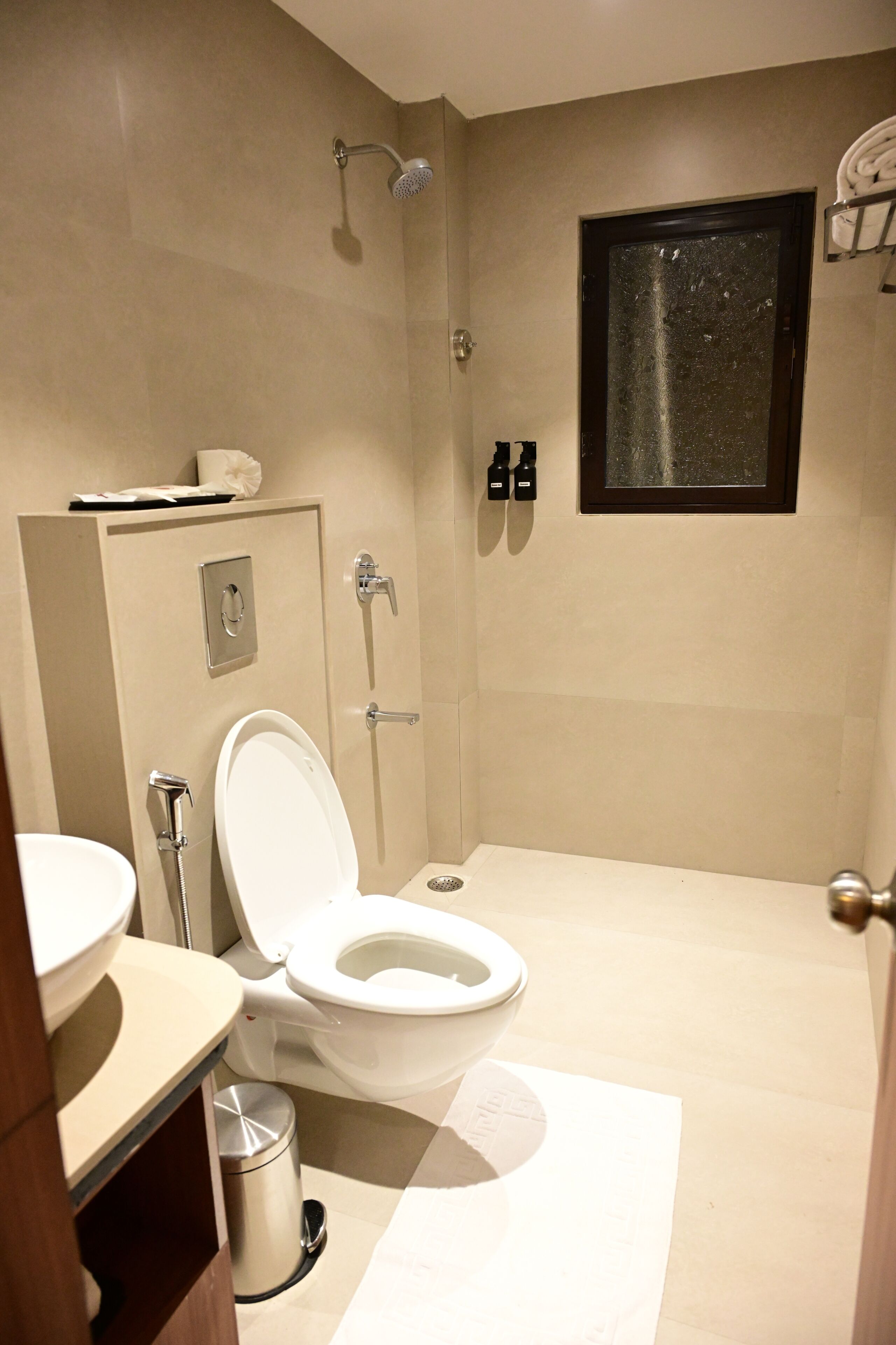 A bathroom with a toilet, bidet, and shower.