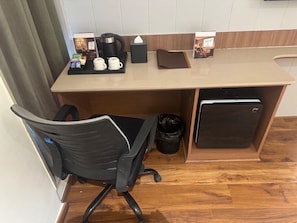A compact kitchenette with a coffee maker, cups, a tissue box, and a small refrigerator. - Trevon Hotel Gujrat Centrale (Ranchi)