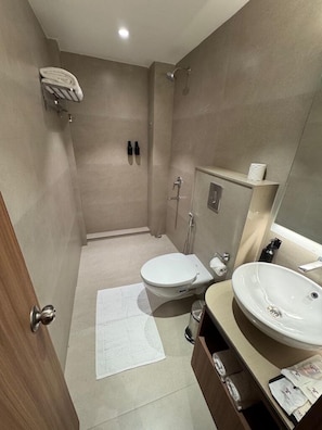 A modern bathroom with a toilet, sink, shower, and towel rack. - Trevon Hotel Gujrat Centrale (Ranchi)