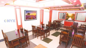 A conference room with wooden tables and chairs, a large window with a view, and a wall-mounted picture.