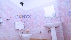 A bathroom with a toilet, sink, and shower.