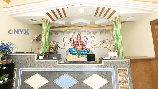 A reception desk with a mural of a deity, a clock, and a sign reading 'ONYX DESTINATIONS'.