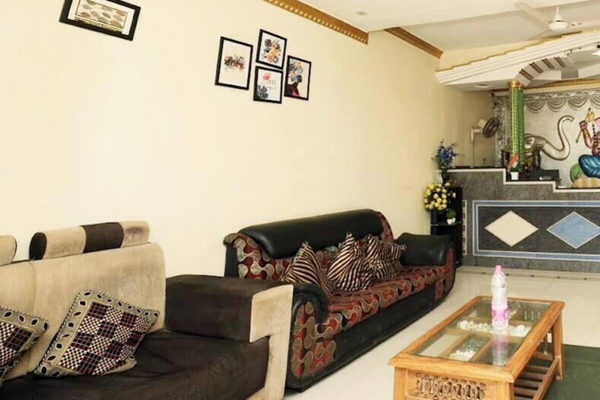 A reception area with a reception desk, two sofas, a coffee table, and framed pictures on the wall.