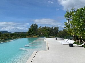 Una piscina con sillas de descanso y vistas a montañas.